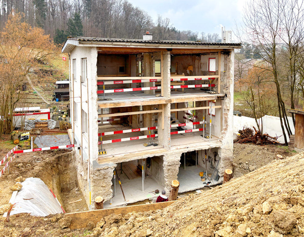 Das 40er Jahre Einfamilienhaus steht in der Freihaltezone. Es gelten strenge Anforderungen, es sind nur geringfügige Änderungen erlaubt. Baustellenfoto. Die hangseitige Fassade wurde abgebrochen, hier wird das Haus mit einem kleinen Anbau verlängert. Im Inneren wird das Haus entkernt und neu aufgebaut.