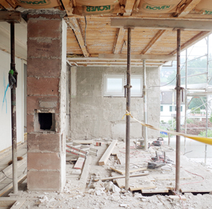 Umbau und Anbau Wohnhaus Meilen. Die ostseitige Giebelfassade wurde komplett entfernt. Der neue Anbau erweitert das Haus um die überhohe, bis ins Dach reichende Wohnhalle mit integrierter Küche. Zur Gewinnung von noch mehr Raumhöhe und somit auch höherer Verglasung der Fassade, wurde die Bodenplatte der Wohnhalle um 3 Stufen abgesenkt. nijo architekten Zürich, Nina und Johannes Wick