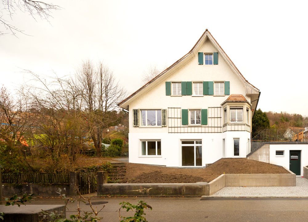 Umbau und Ausbau Kellergeschoss zu einer Wohnung mit neuem unterirdischem Kelleranbau mit von der Strasse zugänglichem Veloabstellraum. Im Keller war vorher eine Garage und Abstelläume. Vergrösserung der Fenster. Absenkung der Bodenplatte für mehr Raumhöhe. dazu mussten die Aussenwände unterfangen werden mit neuen Fundamenten.