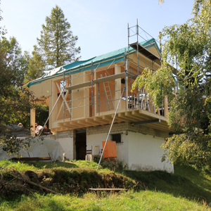 Baustellenfoto Ersatzneubau und Umbau Ferienhaus Toggenburg Wildhaus, Vordere Schwendistrasse, Holzbau auf bestehendem Kellersockel, starke Hanglage, Panoramafenster mit Blick auf Alpstein Säntis. Well-Eternit-Dach. Planung und Bauleitung: nijo architekten Zürich, Nina Wick und Johannes Wick